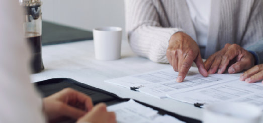 elderly couple looking at a trust document with a lawyer