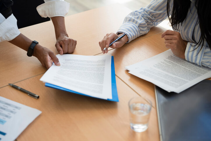 Woman signing documents with business attorney