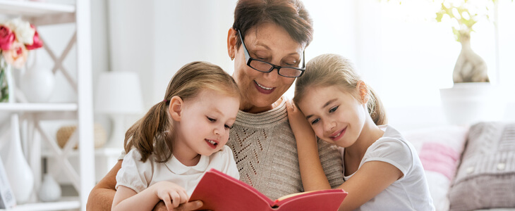 A grandma reading a book to her grandchildren