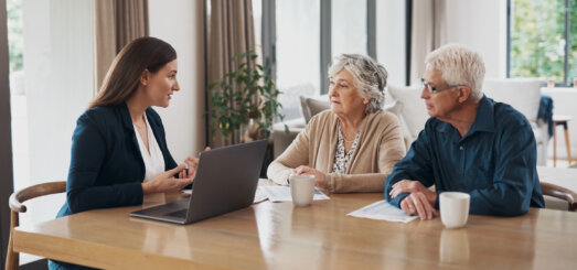 estate planning lawyer talking to an elderly couple about wills and trusts