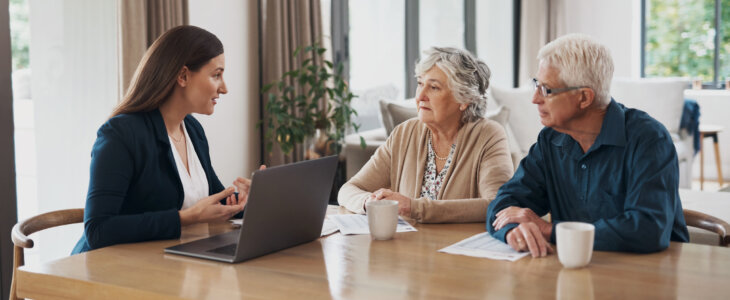 estate planning lawyer talking to an elderly couple about wills and trusts