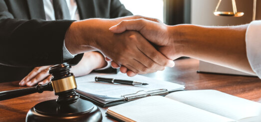 Business attorney shaking hands with client across desk