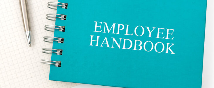 Employee Handbook or manual with a pen and paper on a white table in an office