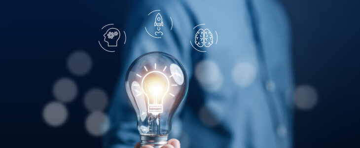 Man hand holding lightbulb with learning educate and graduation concept.