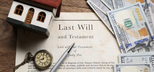 Last Will and Testament, pocket watch, dollar bills, house model and pen on wooden table