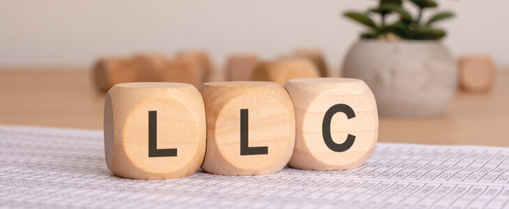 three wooden blocks displaying LLC