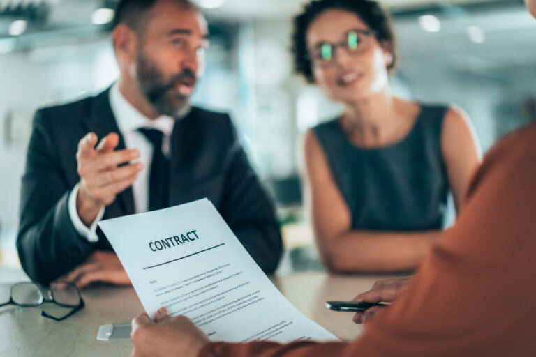 A team of professionals collaborates over a contract
