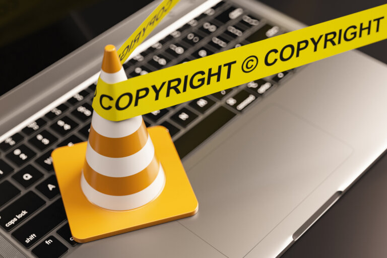 Copyright Protection Concept with a Yellow Caution Tape on a Laptop