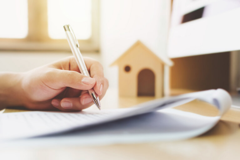 Close up hand of man signing signature loan document to home ownership